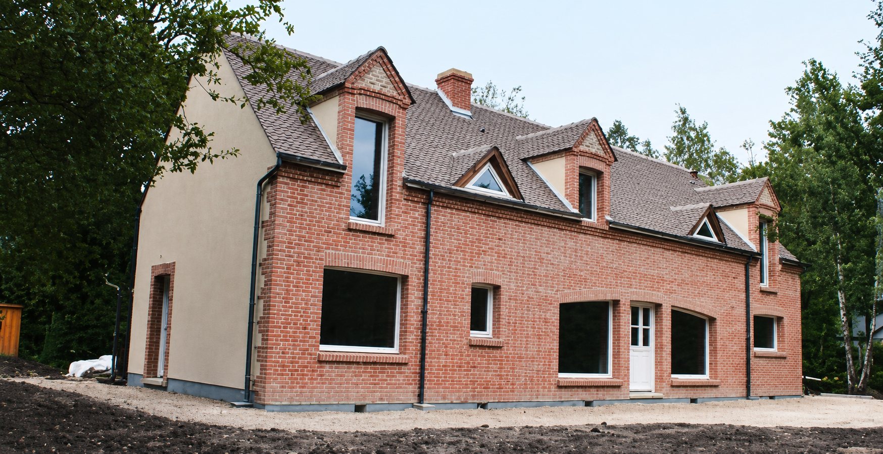 Maison neuve en briques rouges et toit en ardoise